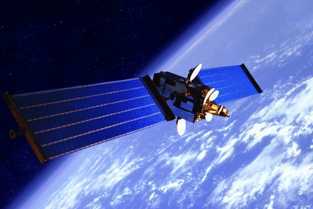 A satellite, with the earth floating in space behind it